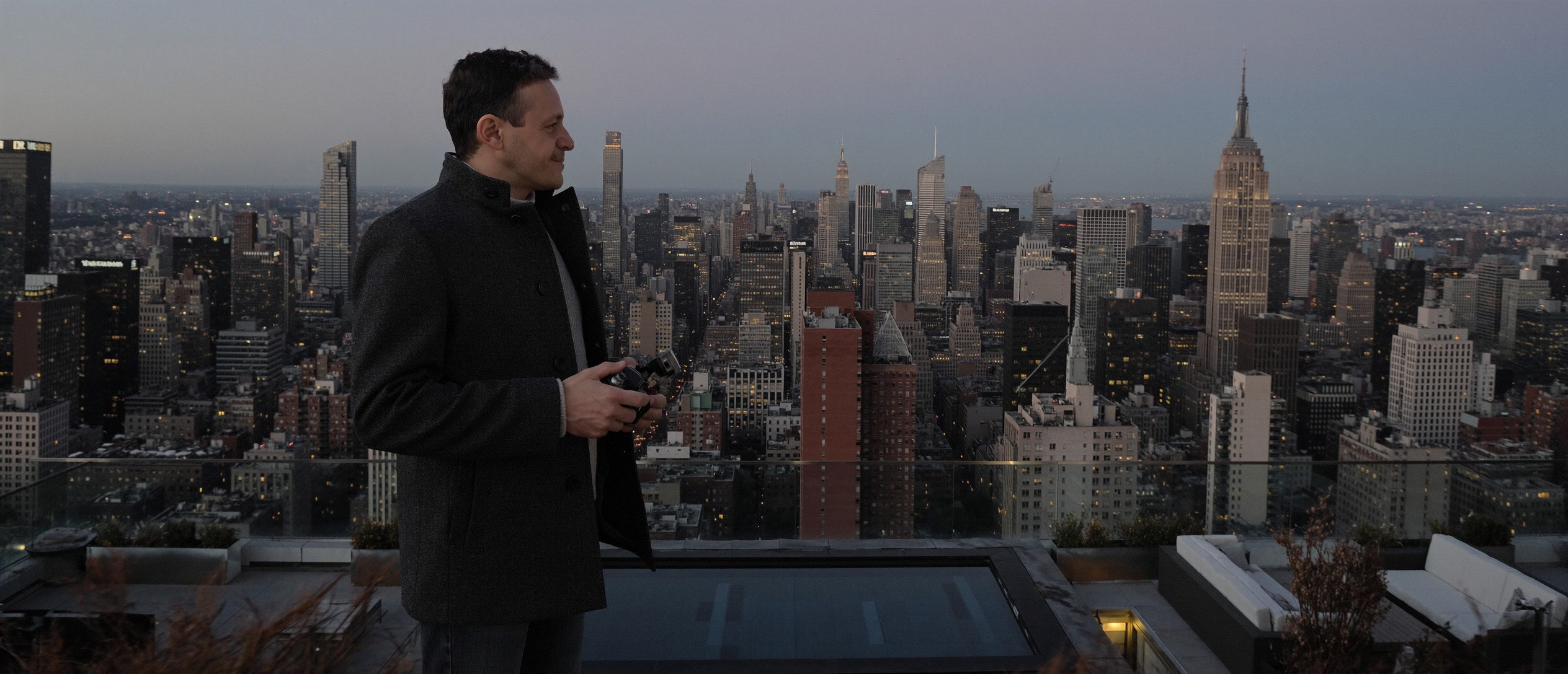 Roberto Pereira Eisenlohr overlooking the Manhattan skyline at dusk - panoramic